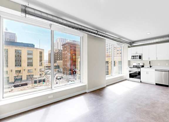 A kitchen with white appliances and a view of the city.