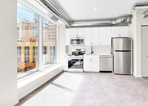 A kitchen with white appliances and cabinets is shown.