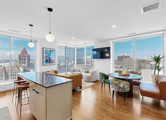 A modern kitchen with a large island and a view of the city.