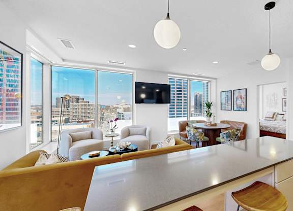 A modern kitchen with a large island and a view of the city.