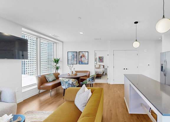 A modern kitchen with a yellow sofa and a wooden floor.