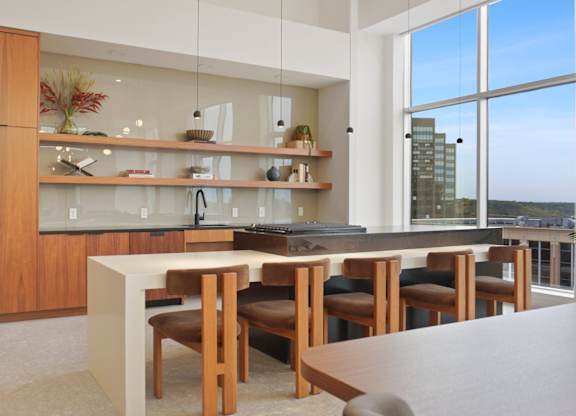 A modern kitchen with a large island and a view of the city.