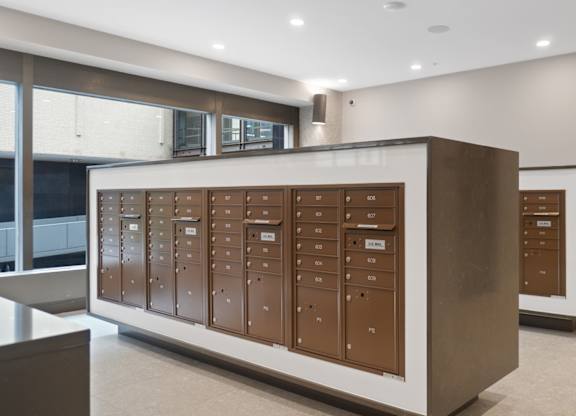 A row of brown mailboxes are lined up on a wall.