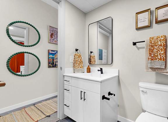 A white toilet sits next to a white cabinet in a bathroom.