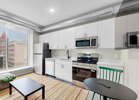 A kitchen with white cabinets and a black countertop.