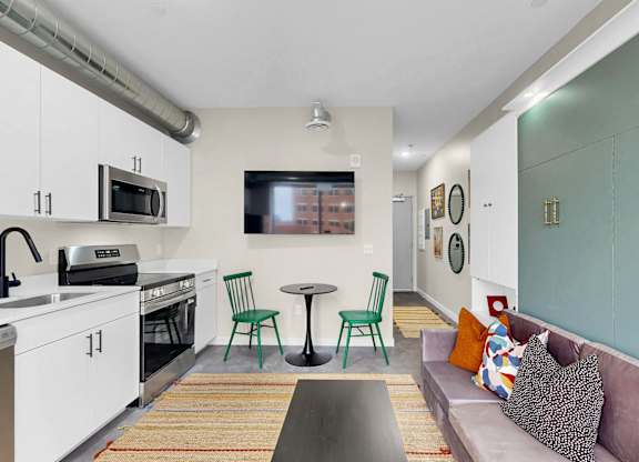 A kitchen with a table and chairs in the middle of it.