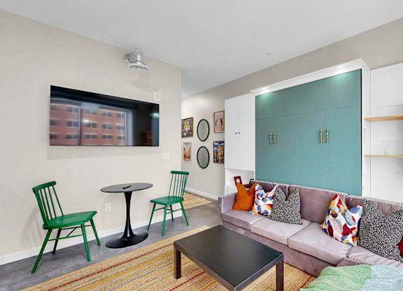 A living room with a grey couch and a green chair.