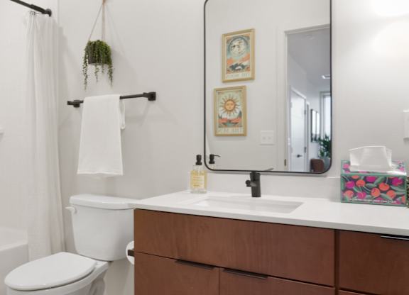 A white toilet sits next to a white sink in a bathroom.