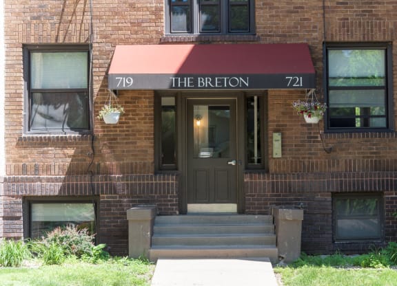 the front of a brick building with a red awning