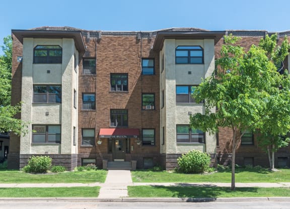 an apartment building with a tree in front of it