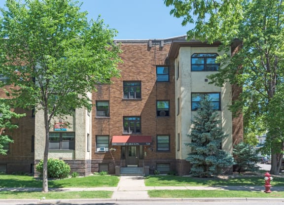 a large brick building with trees in front of it