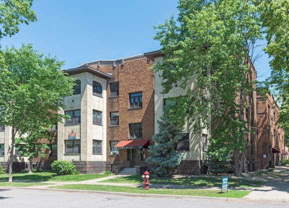 a large brick apartment building with a red fire hydrant