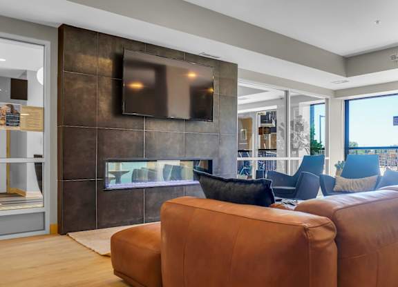 A brown leather couch sits in a modern living room.