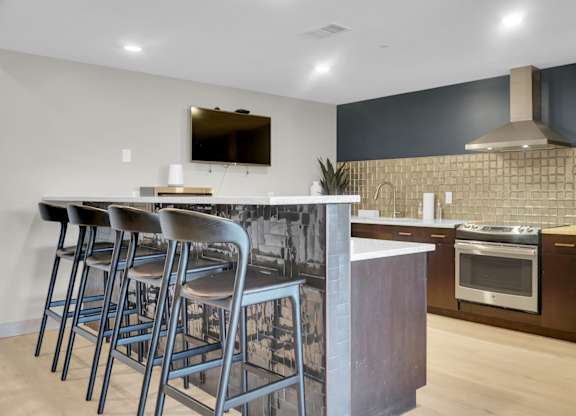 A modern kitchen with a bar area and stainless steel appliances.