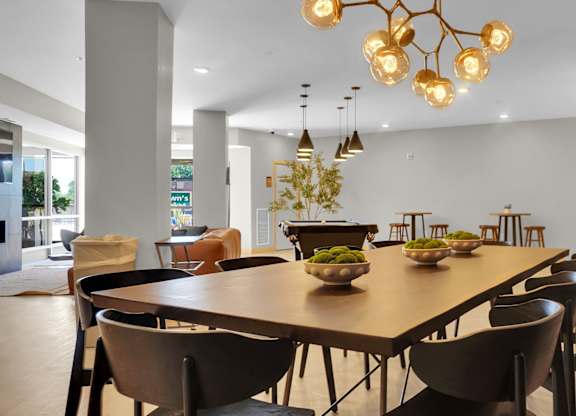 A modern dining room with a large table and chairs.