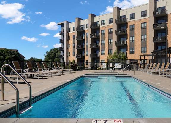 A large swimming pool in front of apartment buildings.