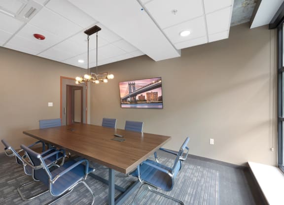 a conference room with a wooden table and blue chairs