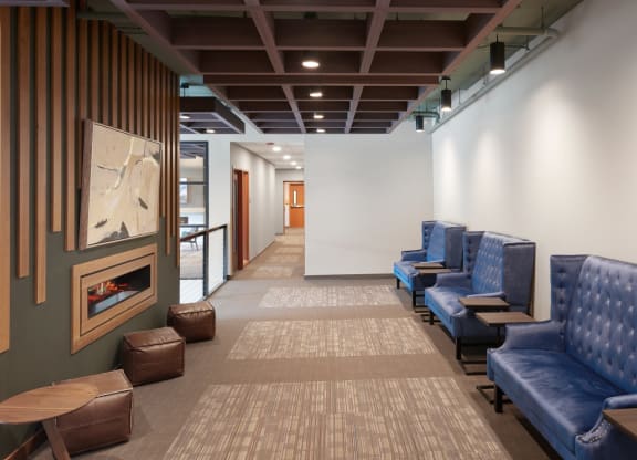 a waiting room with blue chairs and a fireplace