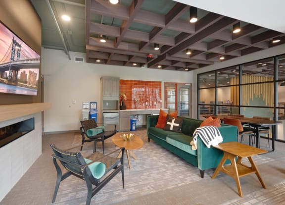a living room with a green couch and chairs and a television