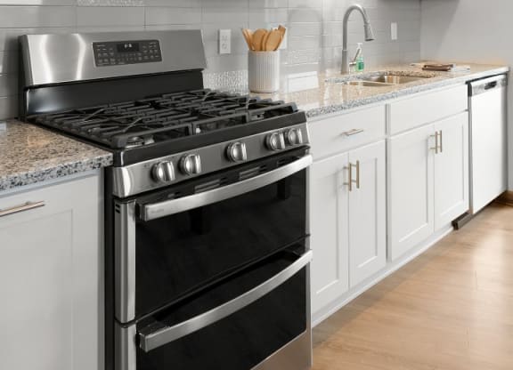 a white kitchen with stainless steel appliances and white cabinets