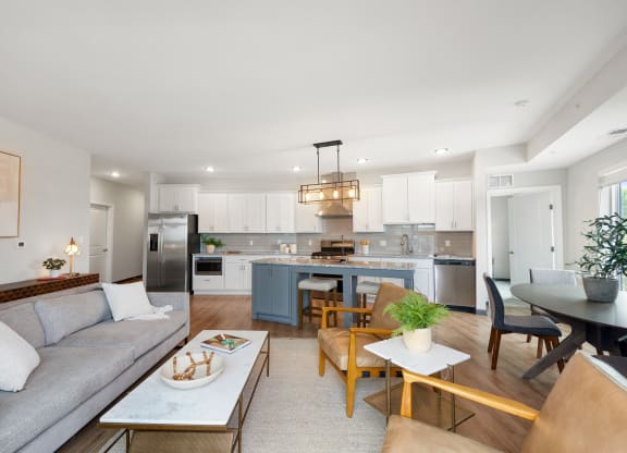 a living room with a couch and a kitchen with a table and chairs