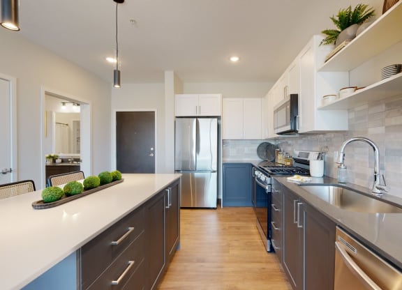 a kitchen with white countertops and gray cabinets at The Exchange Apartments, New Brighton