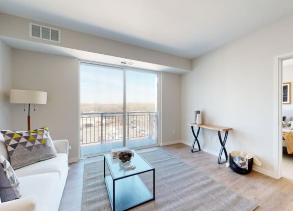 a living room with a large window and a view of a bedroom at The Exchange Apartments, Minnesota, 55112