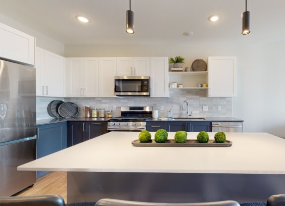 a kitchen with white cabinets and stainless steel appliances at The Exchange Apartments, New Brighton, MN