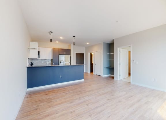 an empty living room with a kitchen at The Exchange Apartments, New Brighton, 55112