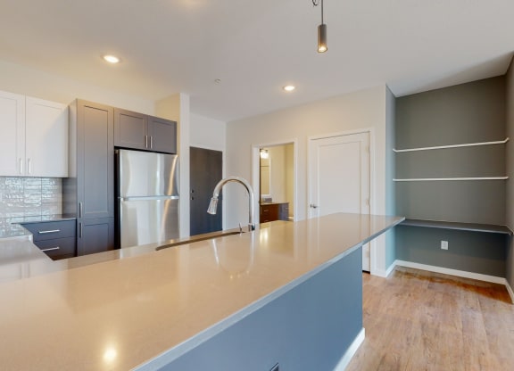 a kitchen with a large counter and a refrigerator at The Exchange Apartments, New Brighton, MN 55112
