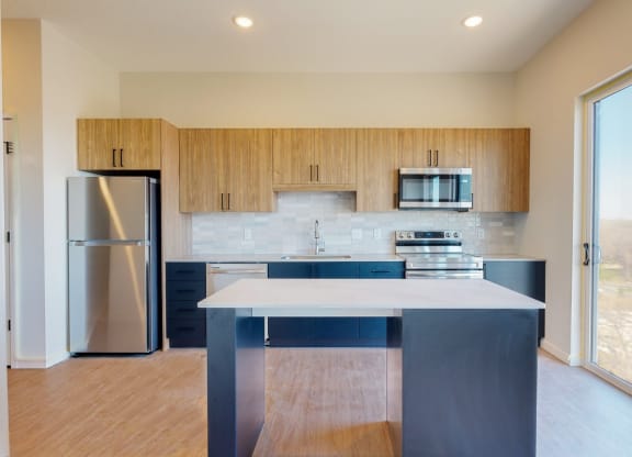 a kitchen with a large island at The Exchange Apartments, New Brighton Minnesota
