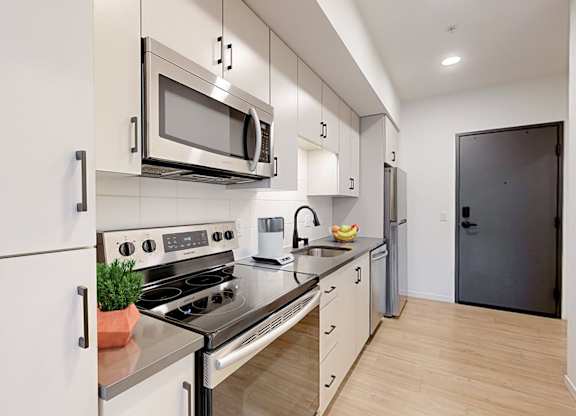 A modern kitchen with a stove, oven, microwave, and refrigerator.