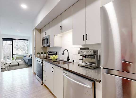 A modern kitchen with stainless steel appliances and white cabinets.