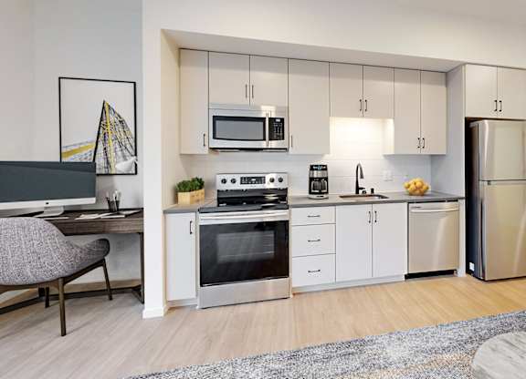 A modern kitchen with stainless steel appliances and white cabinetry.