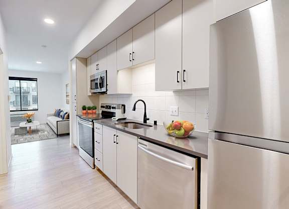 A modern kitchen with stainless steel appliances and white cabinets.