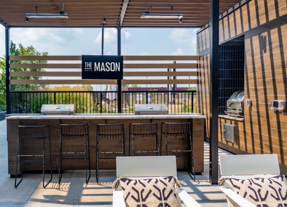 an outdoor patio with a bar and chairs at The Mason, St. Paul, 55114