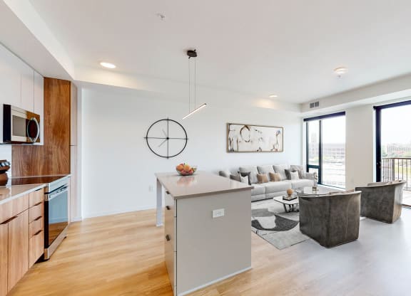 a living room with a couch and a table and a kitchen at The Mason, St. Paul, 55114