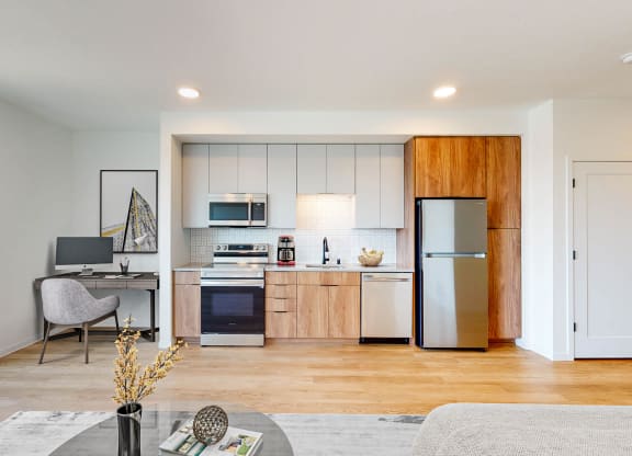 a living room with a kitchen with a refrigerator and a sink at The Mason, St. Paul, 55114