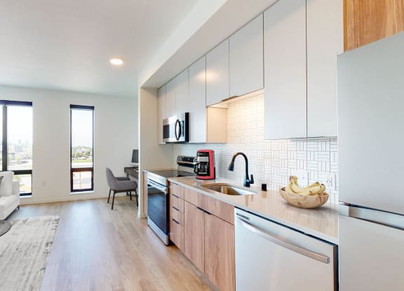 an open kitchen and living room with a view of the city at The Mason, St. Paul, 55114
