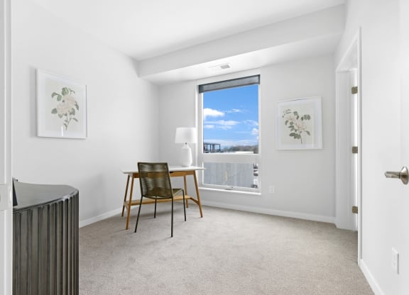 a bedroom with a desk and a window