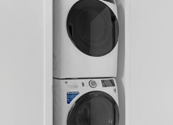 a white washer and dryer in a small laundry room