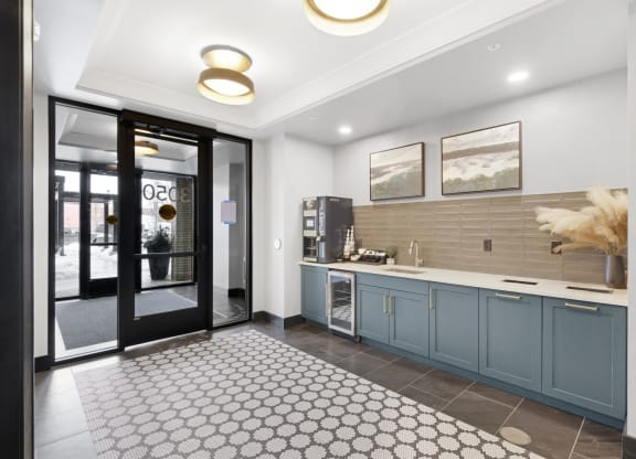 a kitchen with blue cabinets and a black and white rug