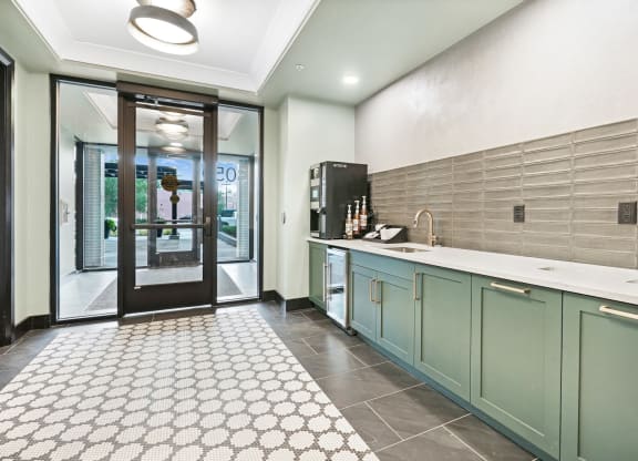 a kitchen with green cabinets and a white tile floor