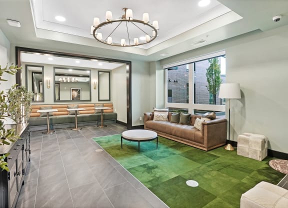 a living room with a green rug and a large chandelier