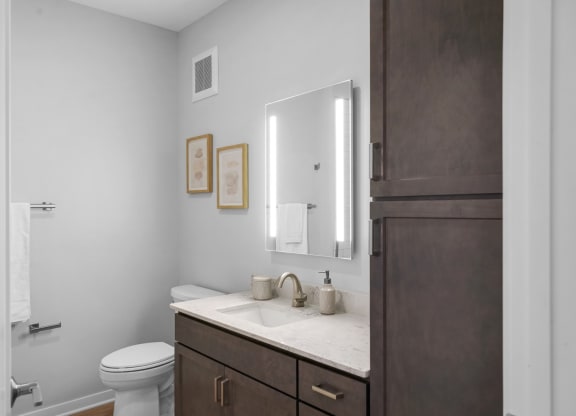 a bathroom with gray walls and a white sink and toilet