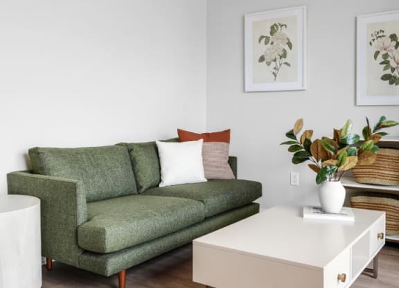 a living room with a green couch and a white coffee table