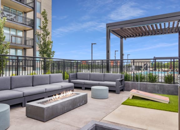 a patio with couches and a fire pit at the district flats apartments in lenexa