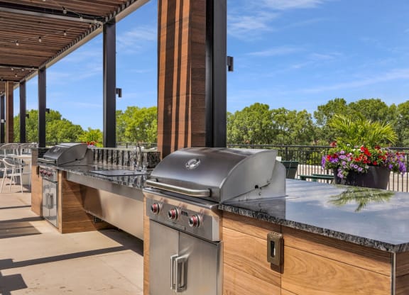 an outdoor kitchen with stainless steel appliances and a bar