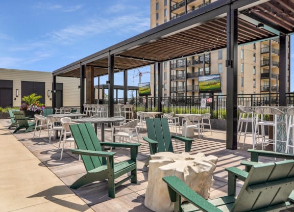 a patio with chairs and tables and a building in the background