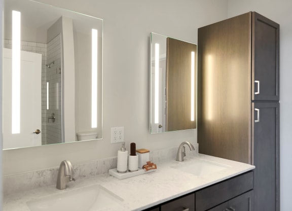 a bathroom with two sinks and two mirrors